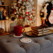 Red mug on a table with a decorated Christmas tree in the background